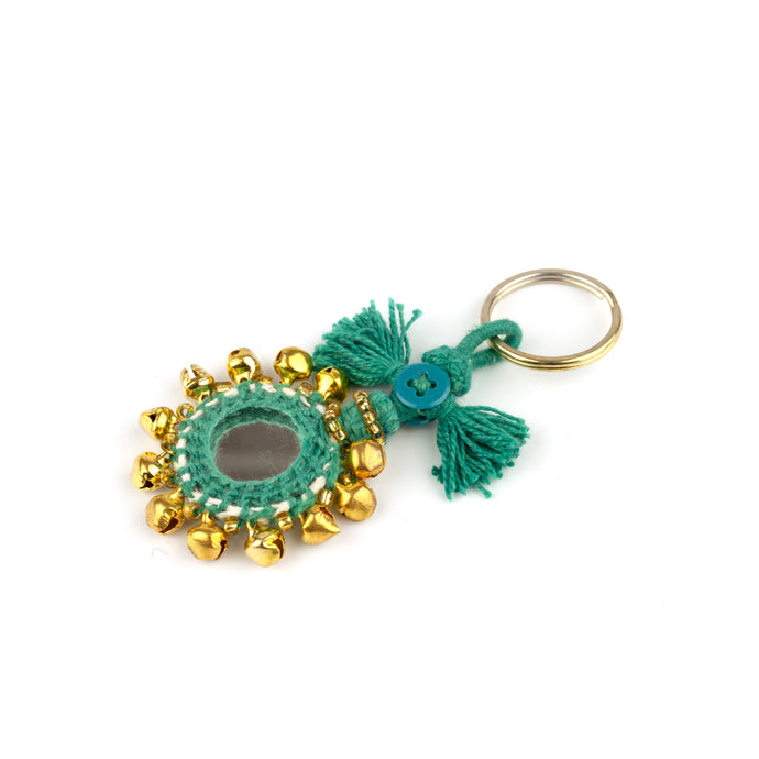 Nyckelring tillverkad av grönt garn, pärlor, speglar och bjällror. Med ring för fastsättning.  Längd exkl. ring: 8,5 cm.