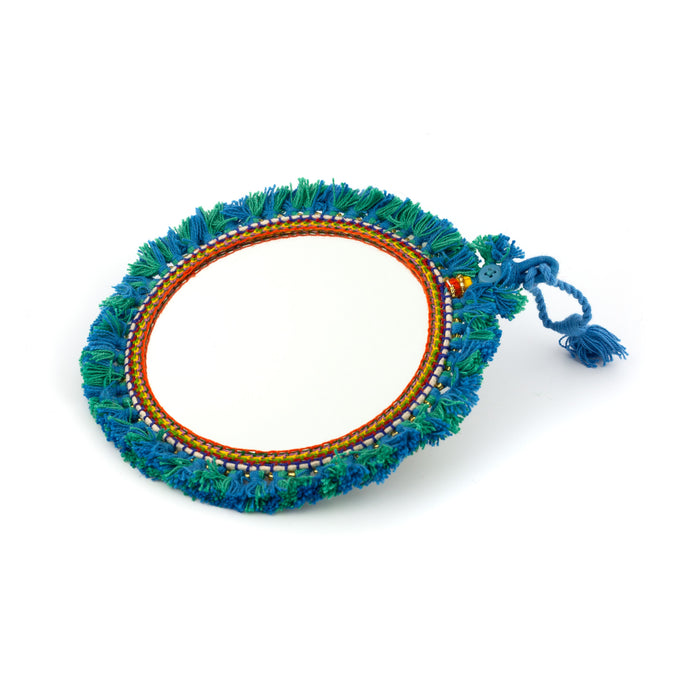 Tvåsidig spegel dekorerad med garn och pärlor. Med snöre för upphängning.  Färg: blå  Storlek: 15 cm i diameter.