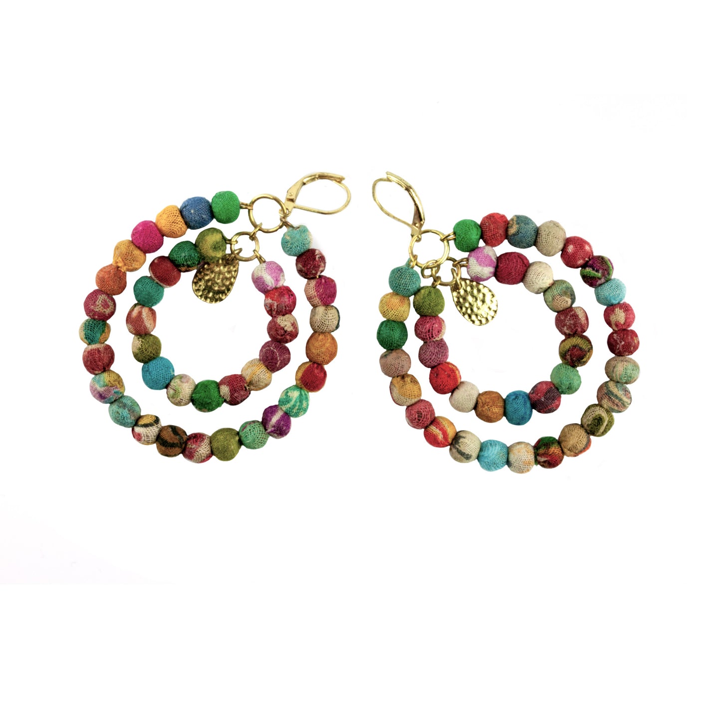 Örhängen tillverkade av återvunnet material och med detaljer av mässingsfärgad metall. Örhängena består av två ringar av runda tygkulor i olika färger och med en mässingsfärgad lövdekoration i mitten. Längd 7 cm.