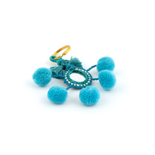 Ladda upp bild till galleriet Nyckelring i blått tillverkad av pompoms, garn, pärlor och spegel.  Med ring för fastsättning.  Längd exkl. ring: 10,5 cm.

