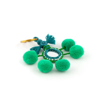 Ladda upp bild till galleriet Nyckelring i grönt tillverkad av pompoms, garn, pärlor och spegel.  Med ring för fastsättning.  Längd exkl. ring: 10,5 cm.
