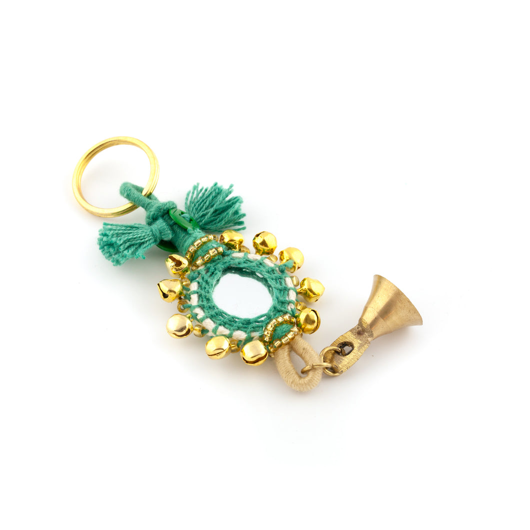 Nyckelring tillverkad av grönt garn, pärlor, speglar och bjällror. Med ring för fastsättning.  Längd exkl. ring: 13,5 cm.