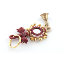 Ladda upp bild till galleriet Nyckelring tillverkad av vinrött garn, pärlor, speglar och bjällror.  Med ring för fastsättning.  Längd exkl. ring: 13,5 cm.
