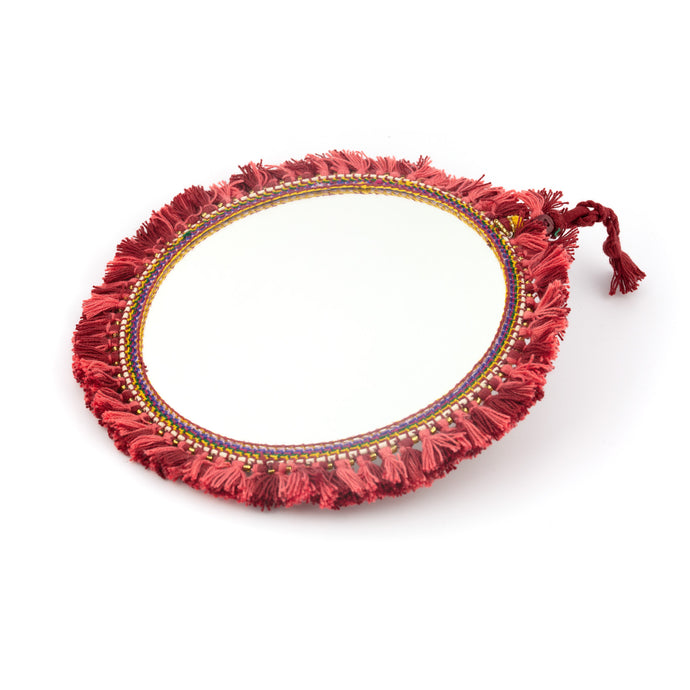 Tvåsidig spegel dekorerad med garn och pärlor. Med snöre för upphängning.  Färg: röd  Storlek: 20 cm i diameter.