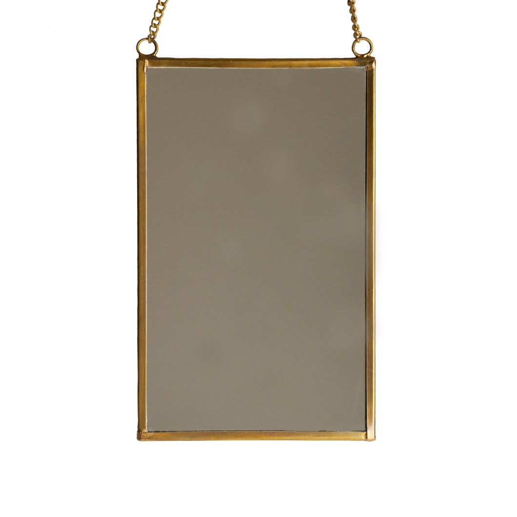 Hängande fyrkantig spegel med kant i mässing och med kedja för upphängning.  Storlek (i cm) 11 b x 17,5 h.